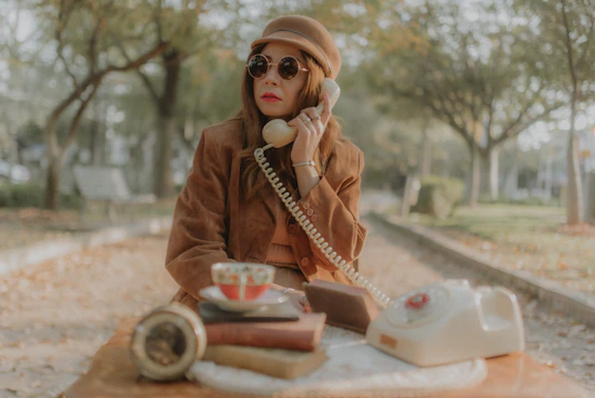 a woman sitting on the ground talking on a phone