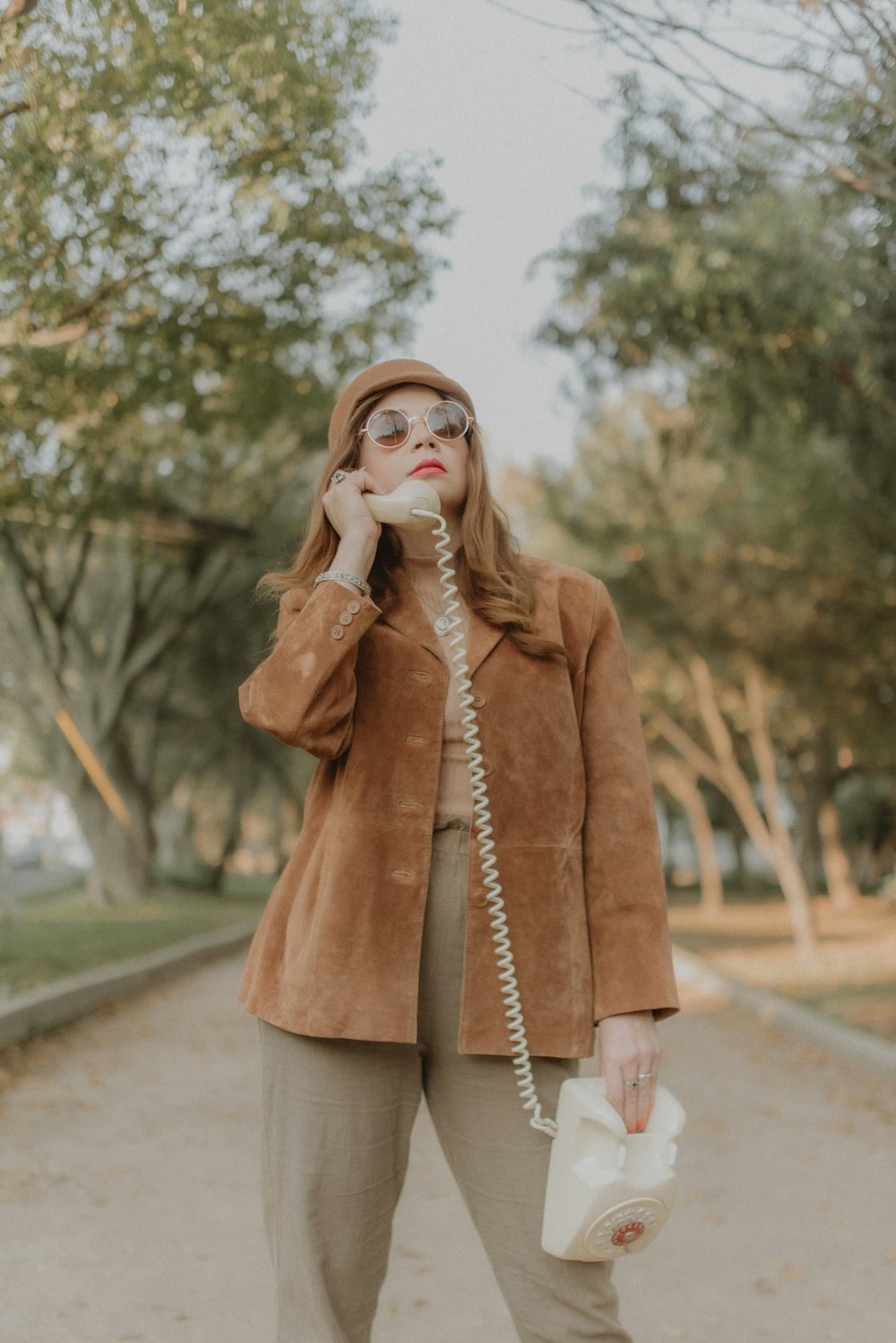 a woman in a brown jacket talking on a phone