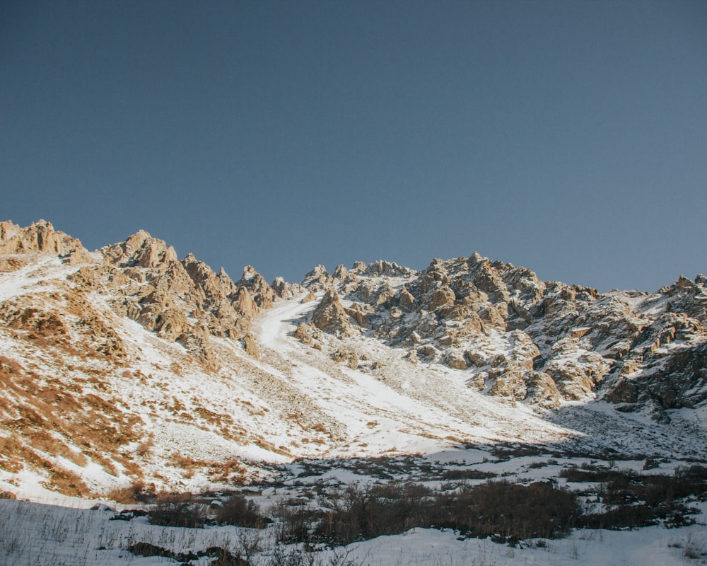 a snow covered mountain range with a clear blue sky