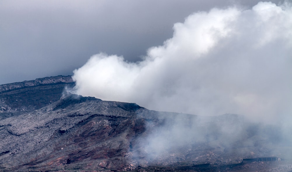 smoke billows from the top of a mountain