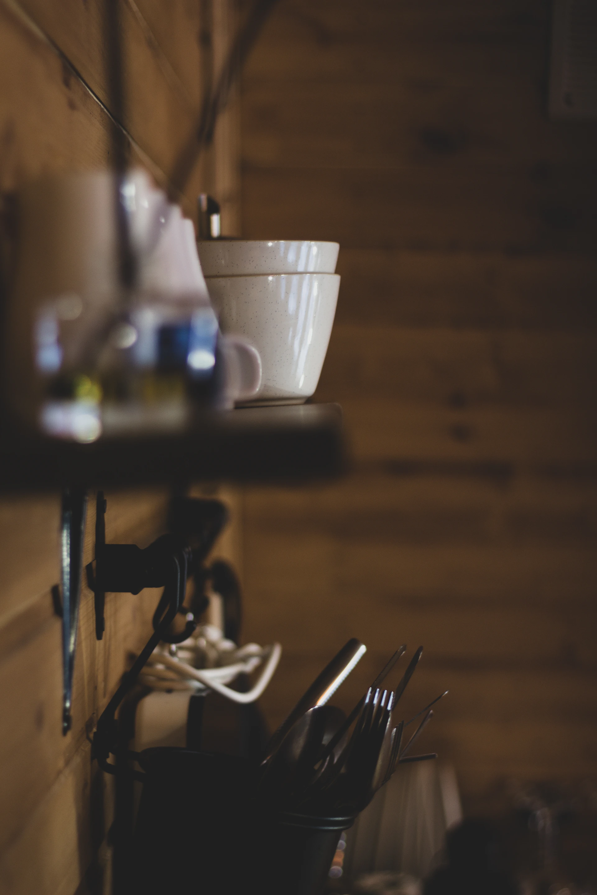 a kitchen area with a bowl and utensils hanging on the wall