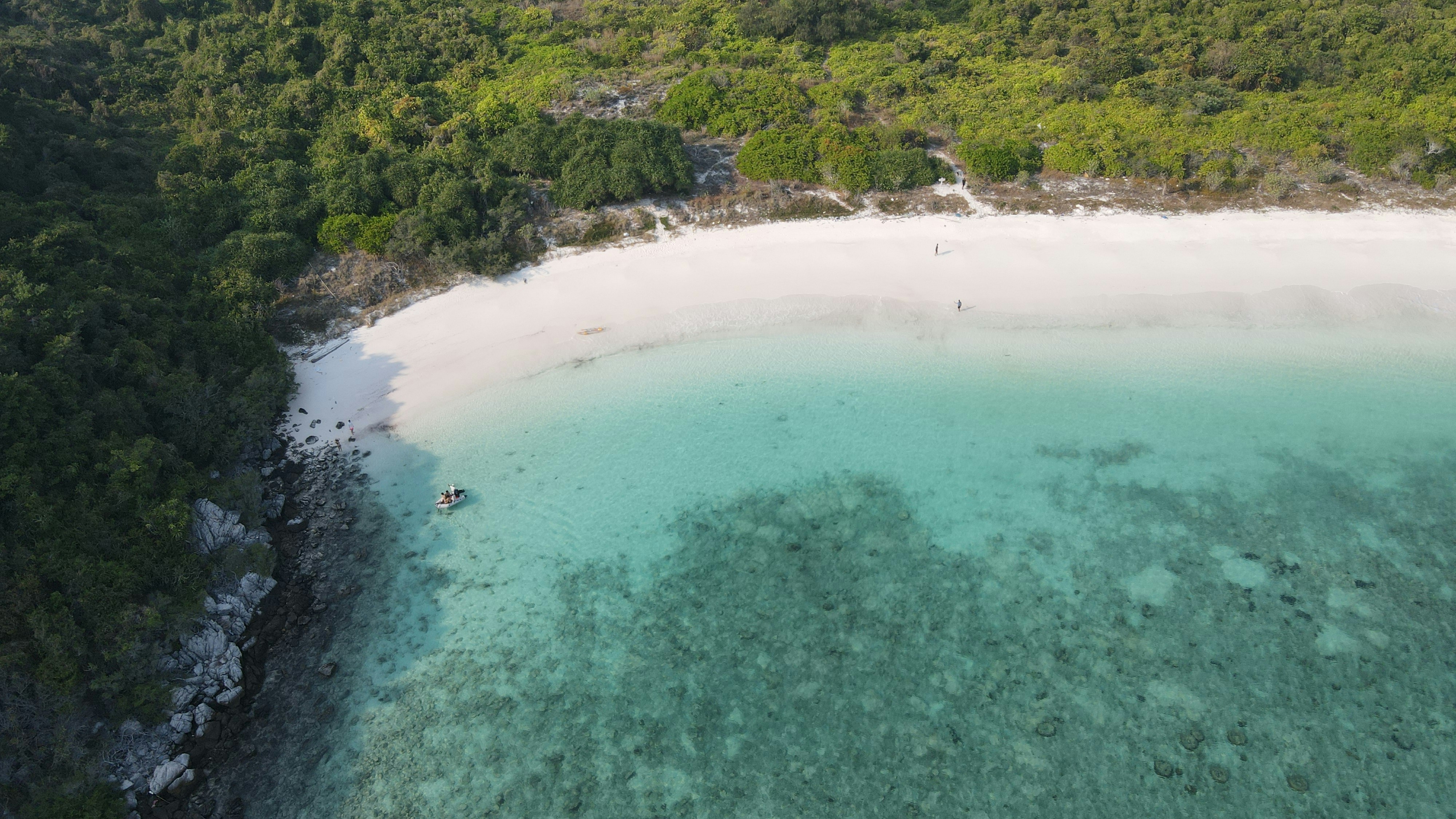 Aerial view of pristine white sand beach surrounded by turquoise water and jungle