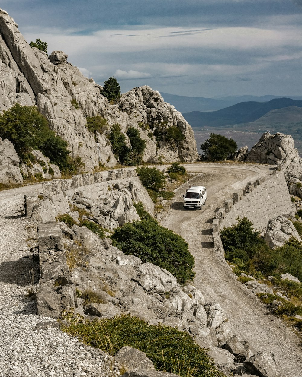 a van is driving down a rocky road