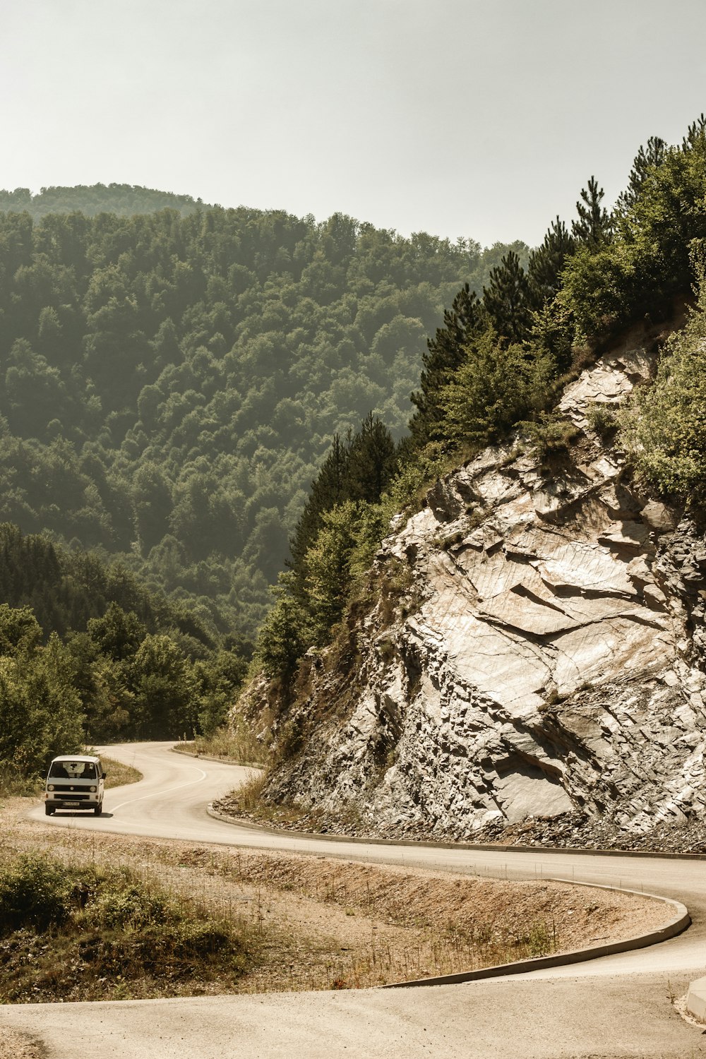 a car driving down a winding road in the mountains