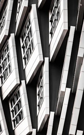 Sleek aluminium window frames in silver and black contrasting with a white wall.
