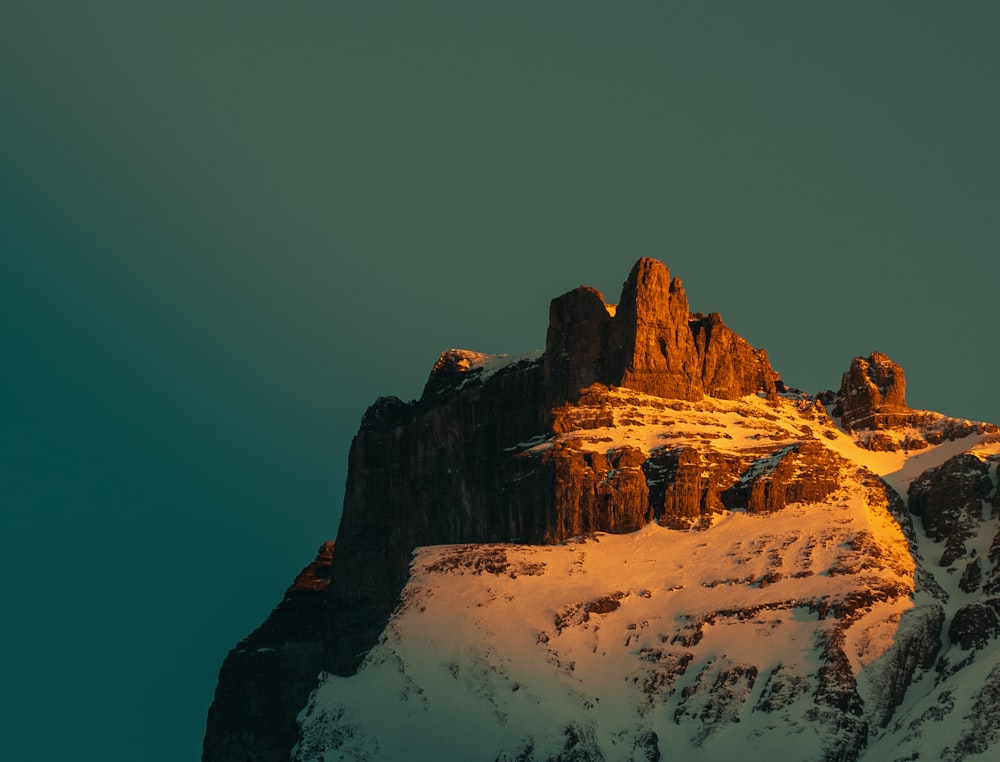 uma montanha coberta de neve com um fundo do céu