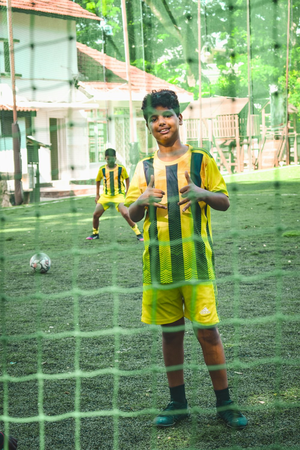 a young boy standing in front of a soccer net