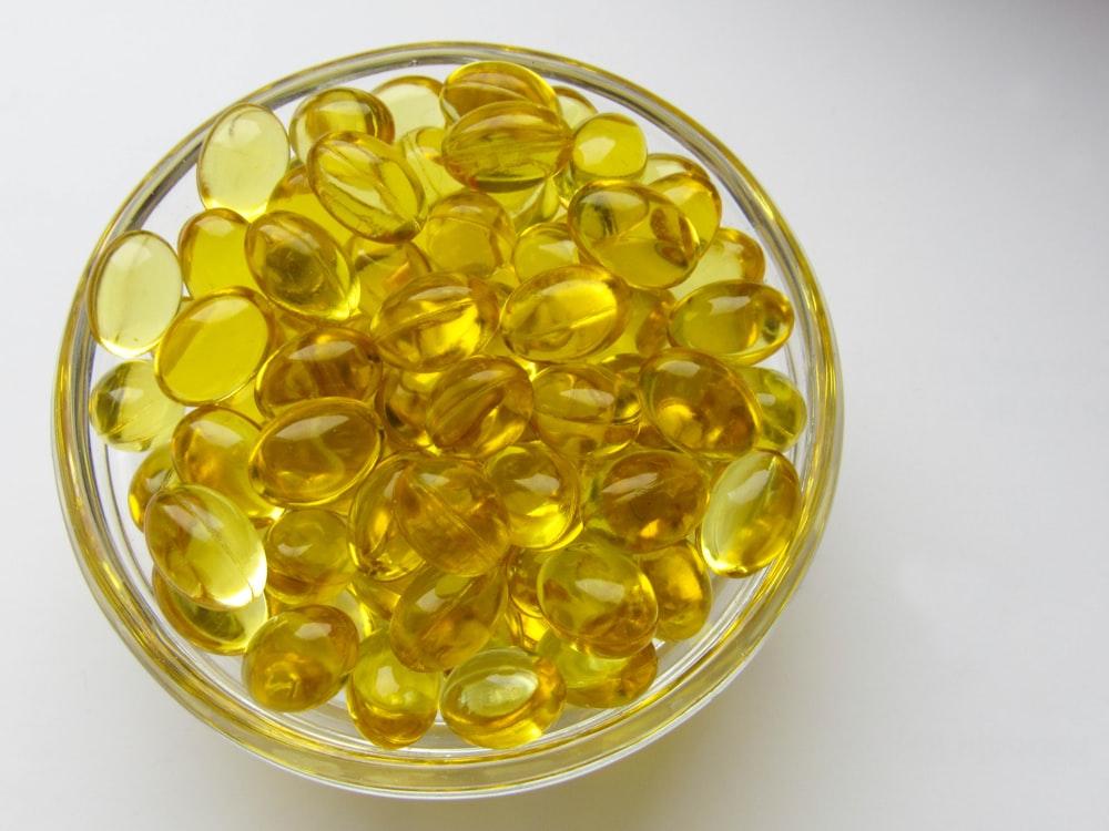 a glass bowl filled with yellow glass beads