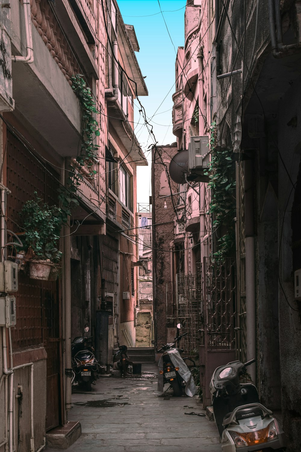 a narrow alley with scooters parked on both sides