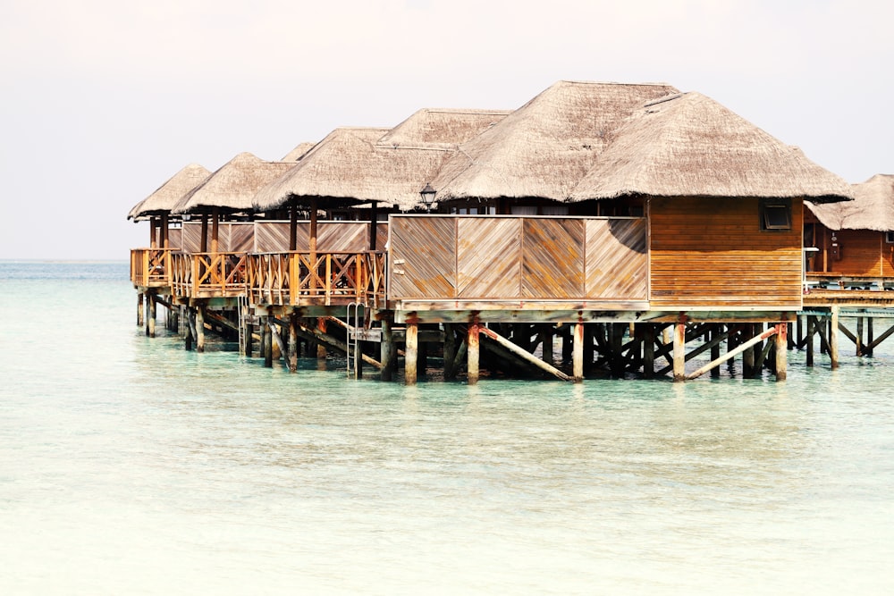 a row of huts sitting on top of a wooden pier