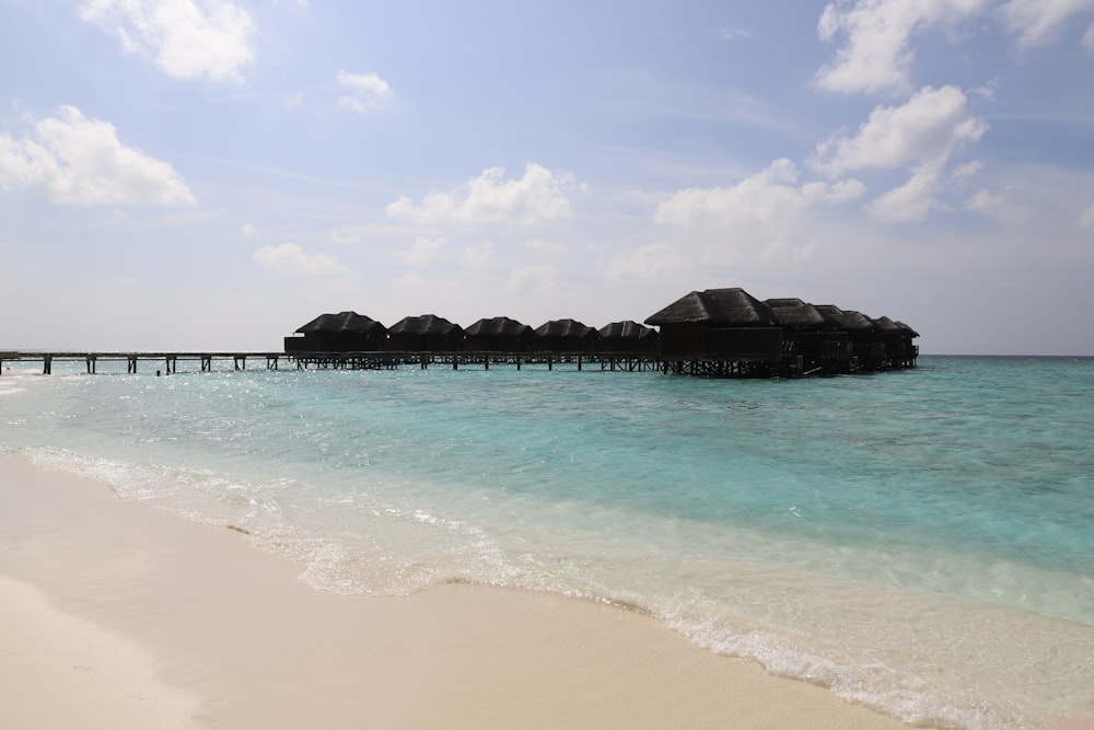 a beach that has some huts in the water