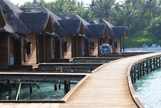 a row of wooden houses next to a body of water