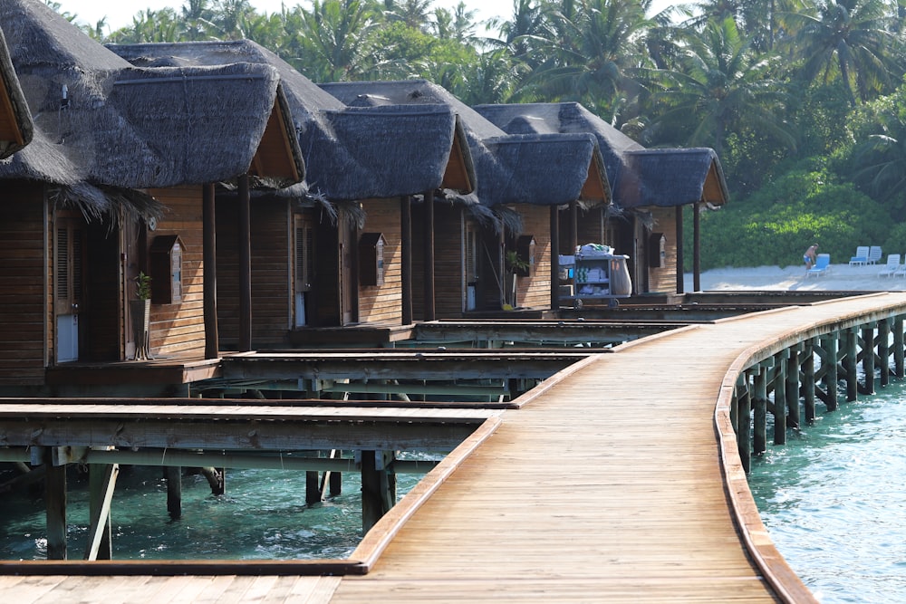 a row of wooden houses next to a body of water