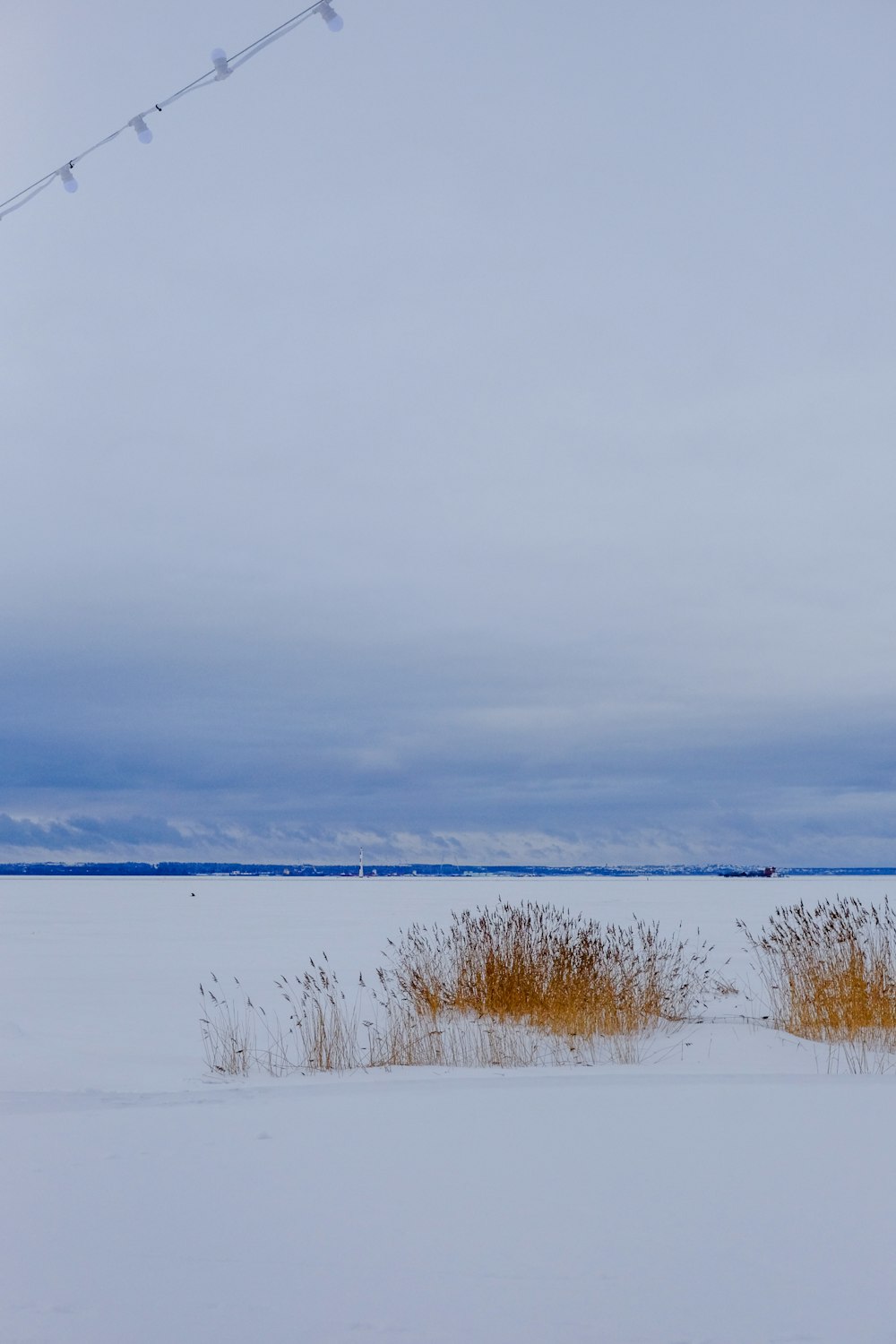 a snow covered field with a power line in the background