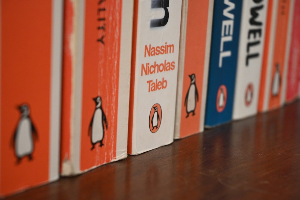 a row of books sitting on top of a wooden table