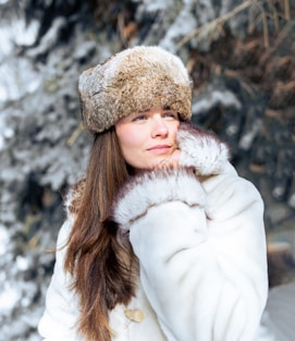 a woman wearing a white coat and a fur hat