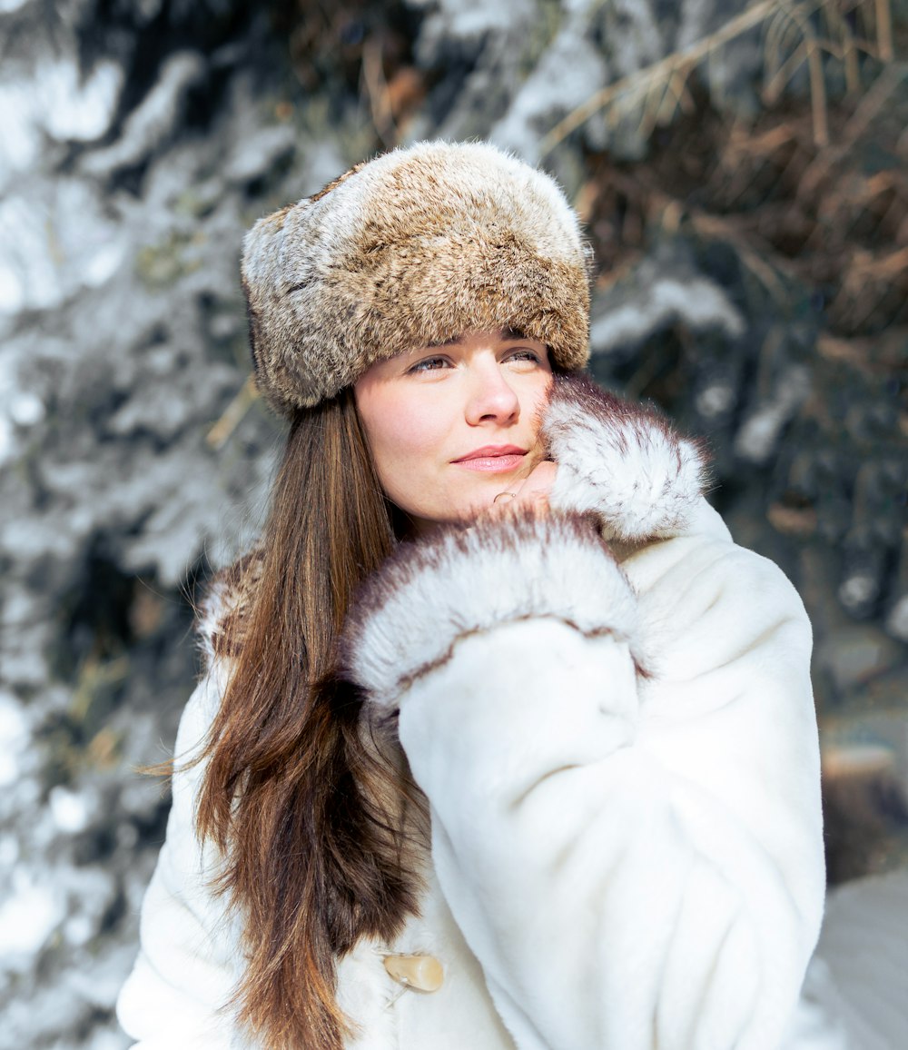 a woman wearing a white coat and a fur hat