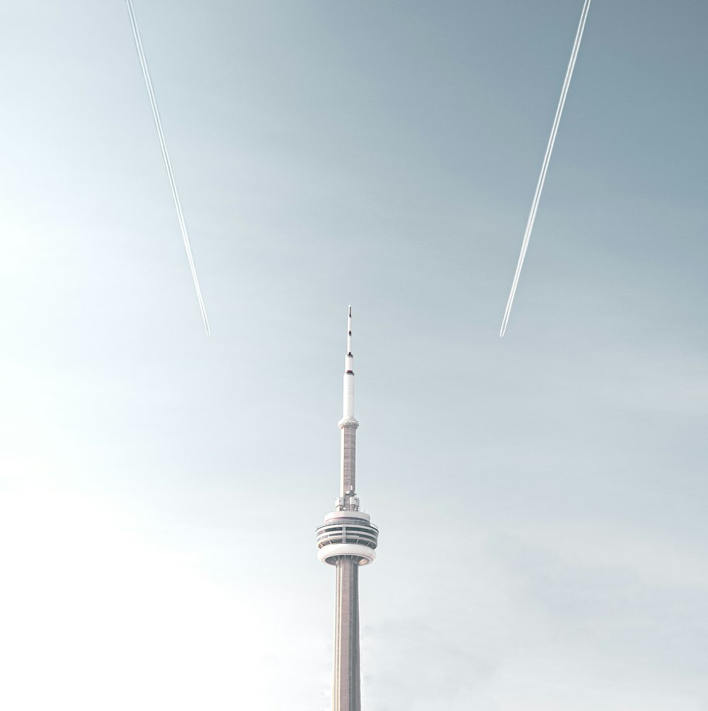 two jets flying in the sky over a tall building