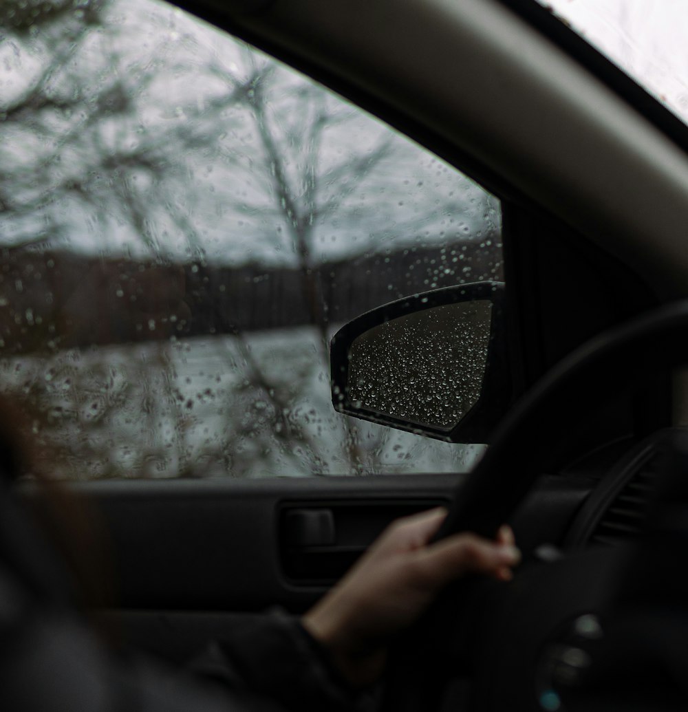 a person driving a car in the rain