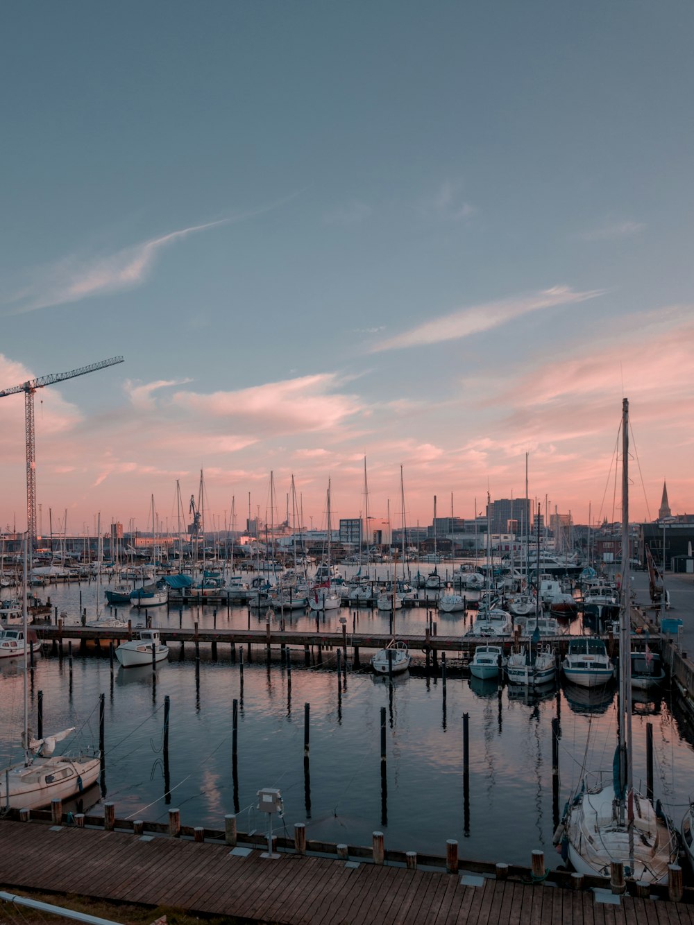 a harbor filled with lots of boats under a pink sky