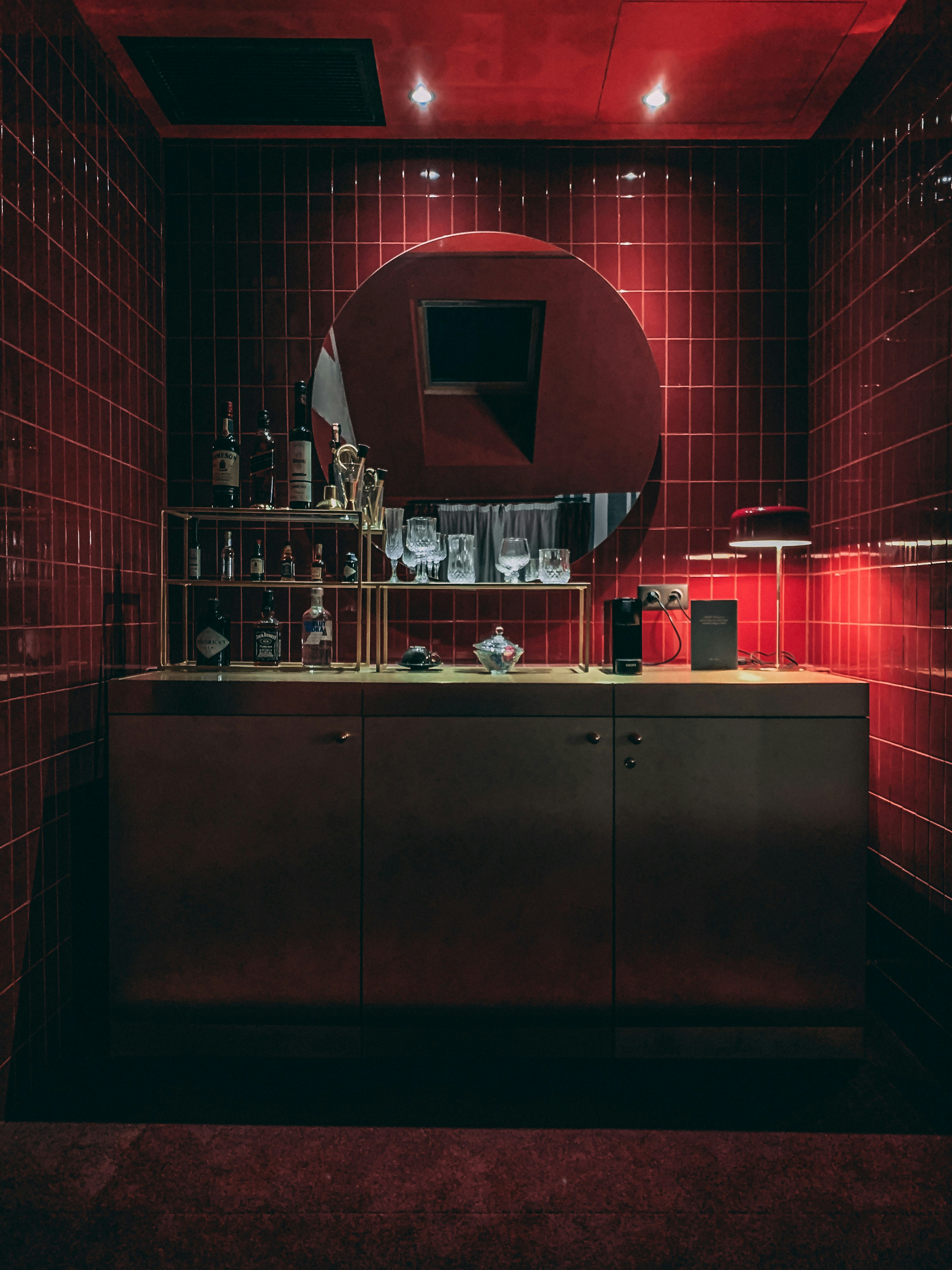 a kitchen with red tiles and a large mirror