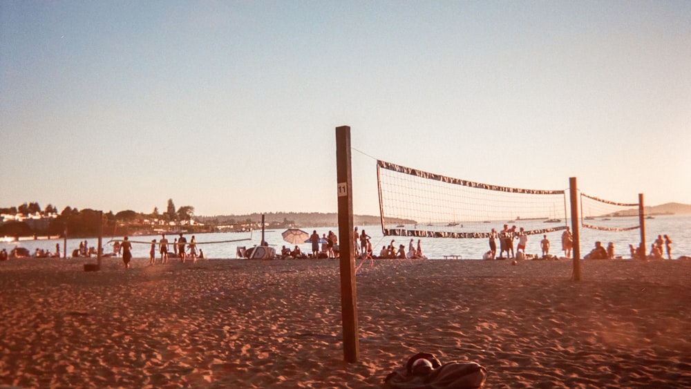 a group of people playing volleyball on a beach