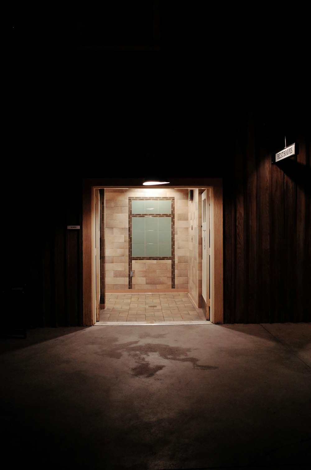 a dark room with an open door and a tiled floor