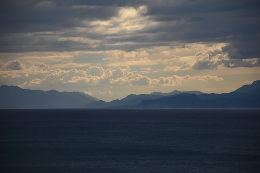 a large body of water with mountains in the background