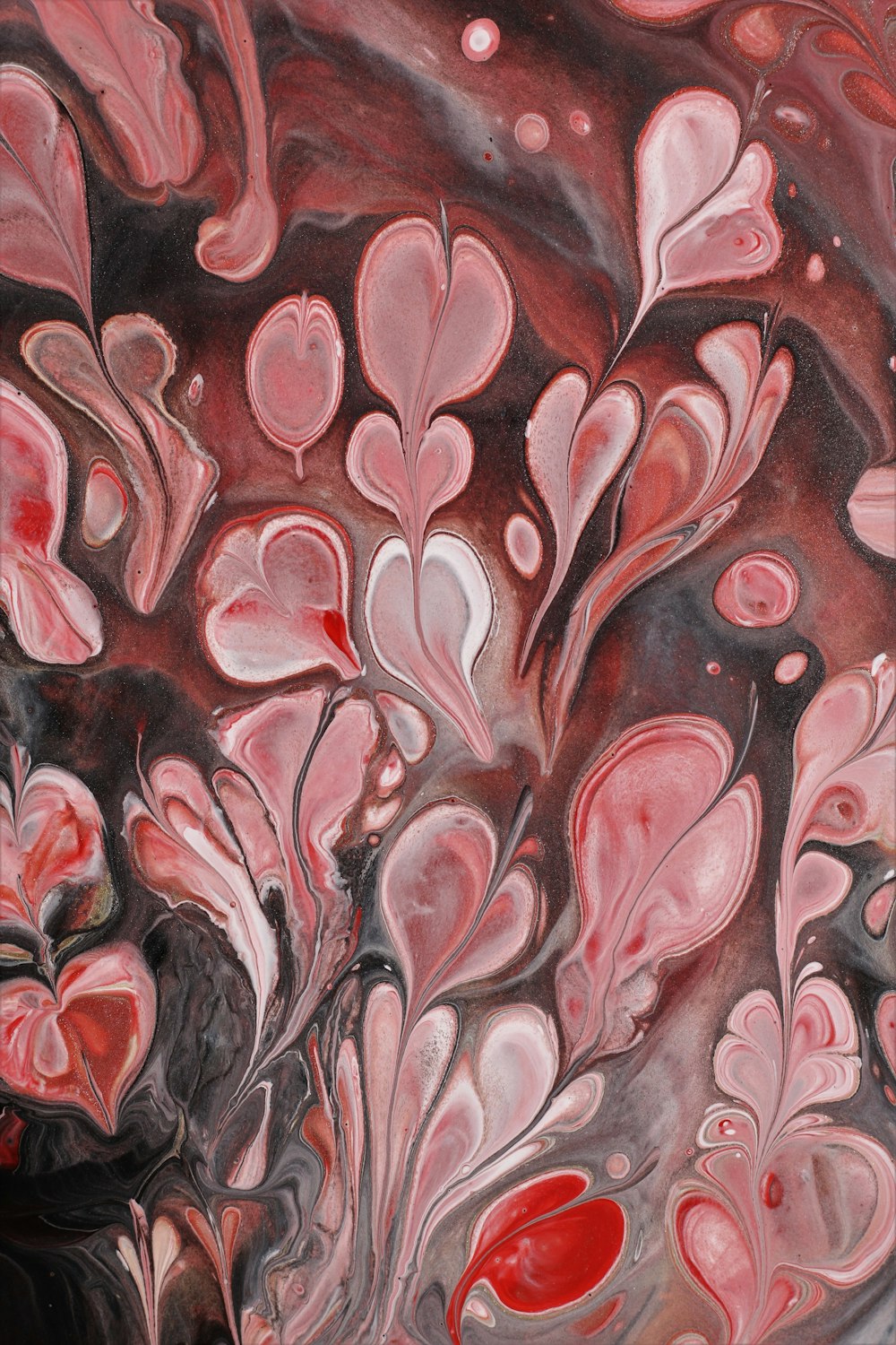 a close up of a painting with red and black colors