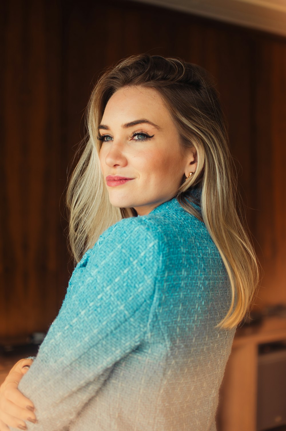 a woman standing in a kitchen wearing a sweater