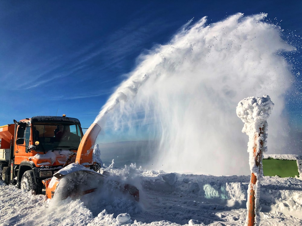 a snow blower is spraying snow onto the ground