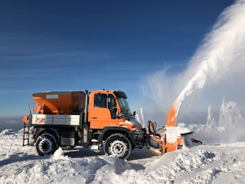a snowplow clearing the snow off of a mountain