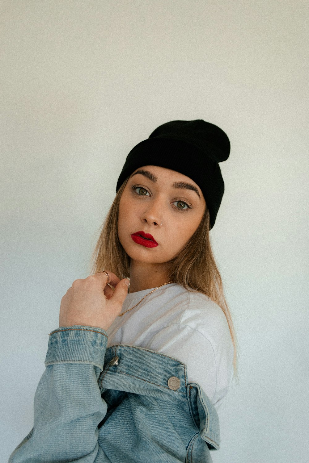 a woman wearing a black beanie and a white shirt