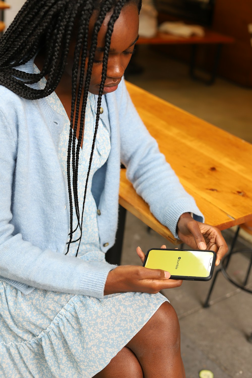 une femme assise sur un banc utilisant un téléphone cellulaire