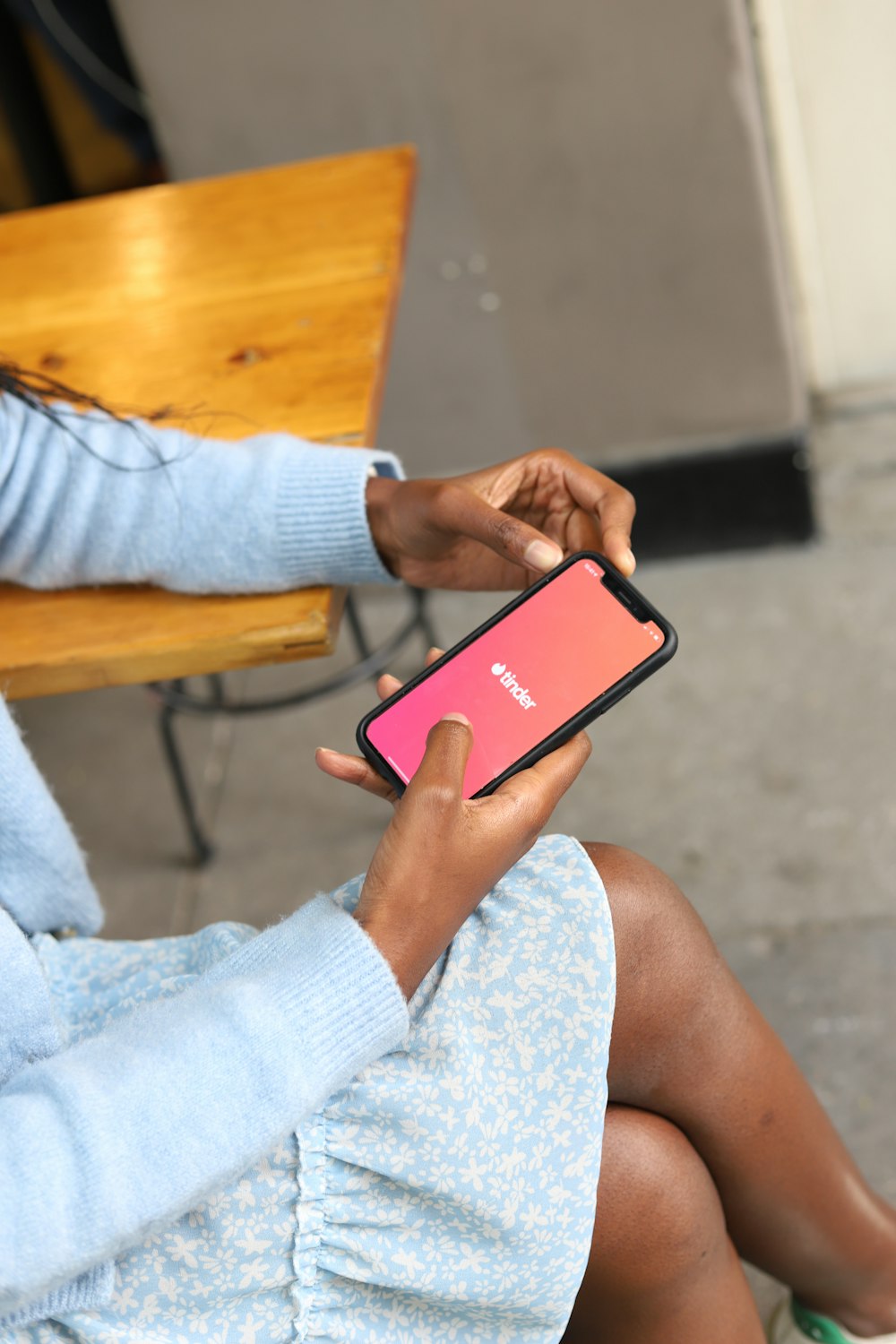 a woman sitting on a bench holding a cell phone