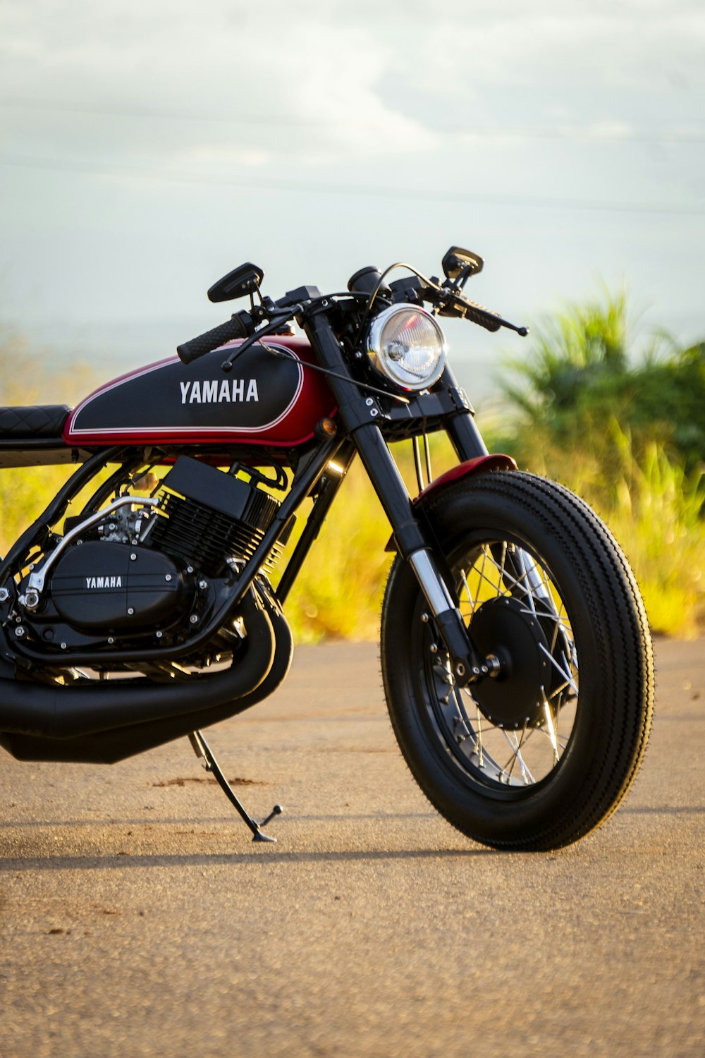 a red and black motorcycle parked on the side of a road