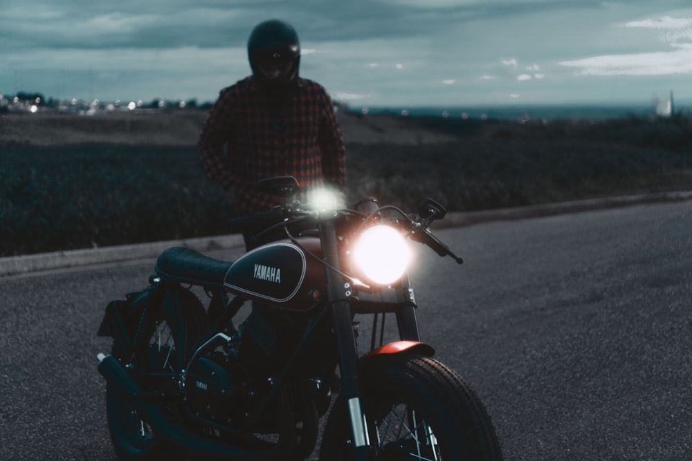 a man riding on the back of a motorcycle down a road