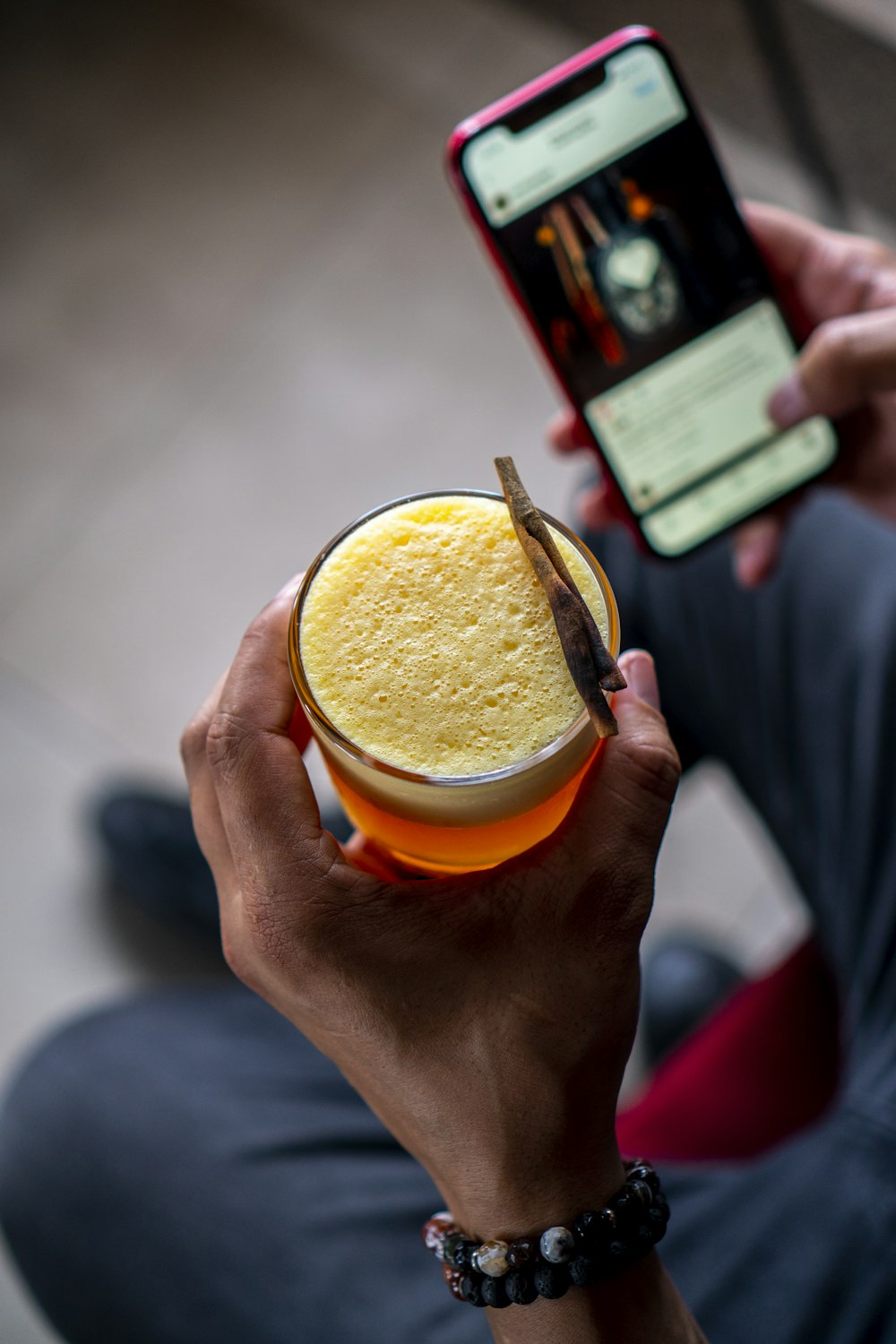 a person holding a cell phone and a bowl of food