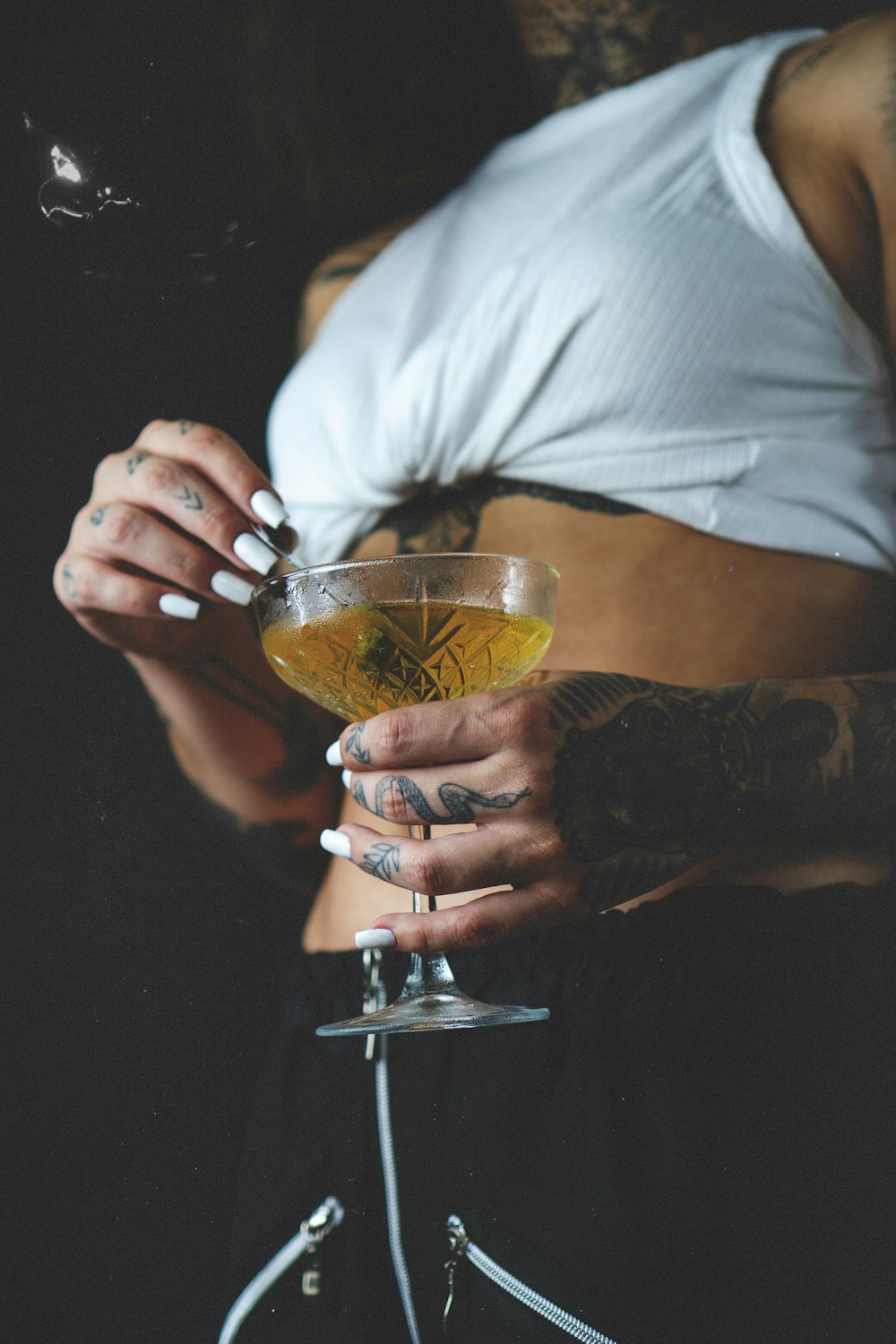 a woman holding a glass with a drink in it