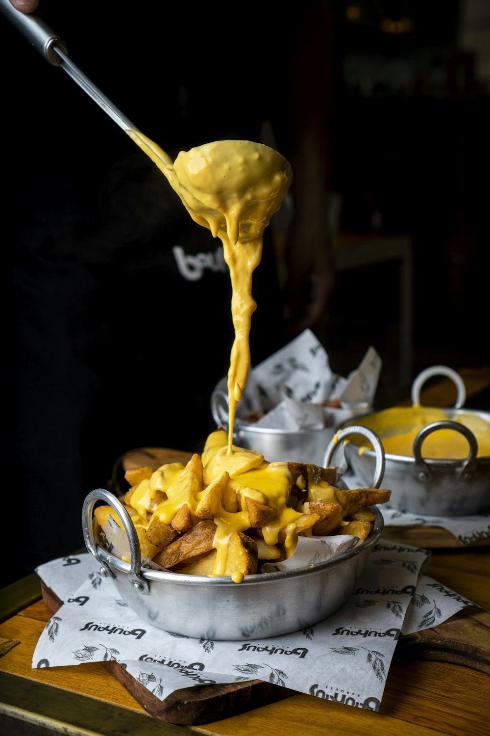 a person pouring sauce over a bowl of food