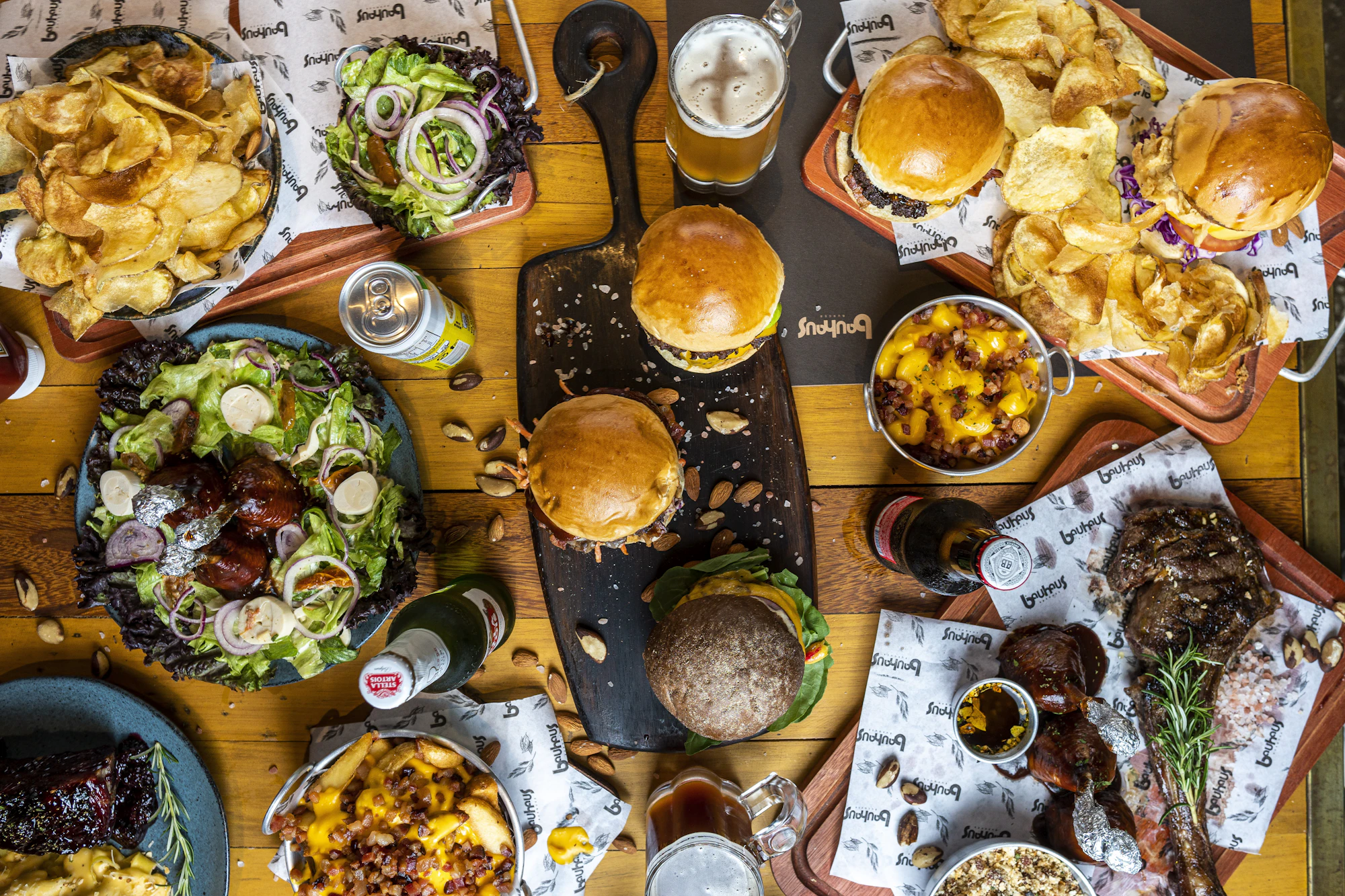 A table from above, covered in burgers, fries and salads