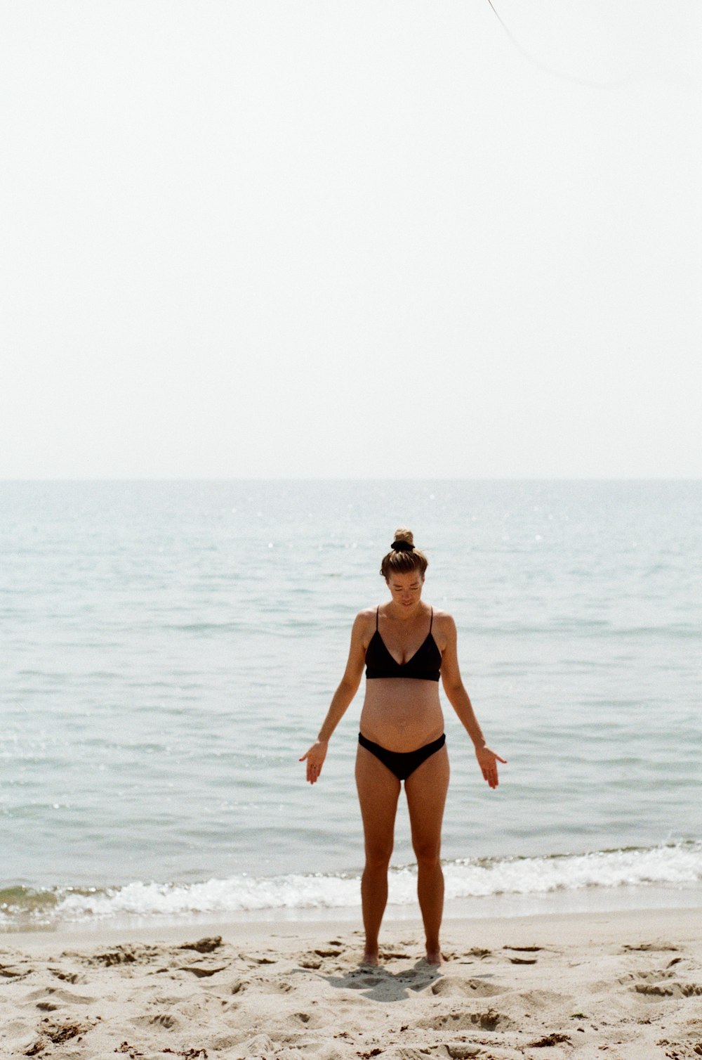 a woman standing on top of a sandy beach