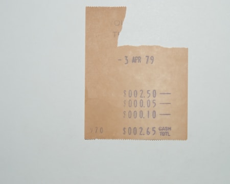 A partial vintage receipt dated 3 April 1979 is displayed on a plain background. The receipt shows amounts of $2.50, $0.05, $0.10, with a cash total of $2.65. It has a slightly torn upper section and faded text suggesting wear and age.