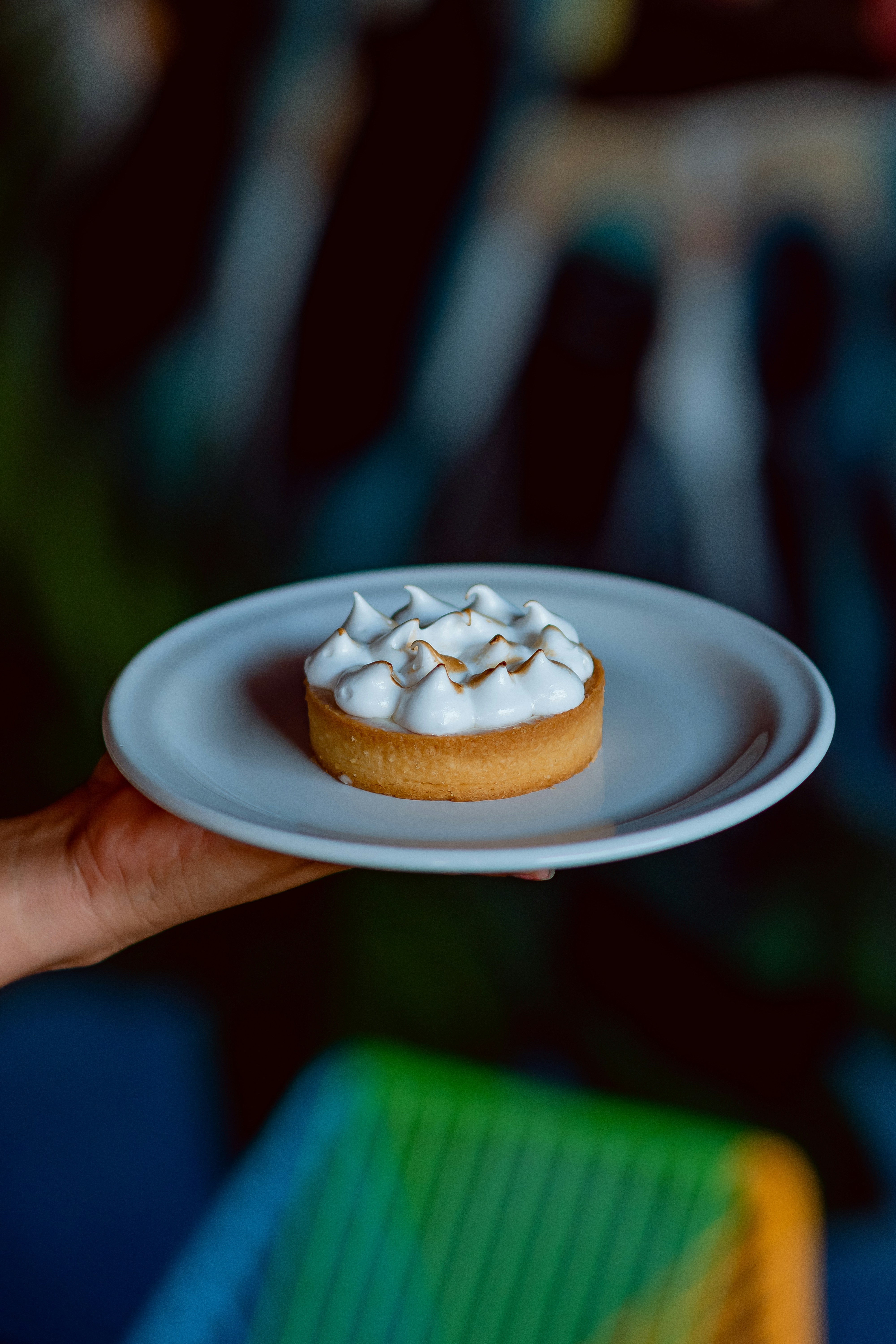 a person holding a plate with a pastry on it