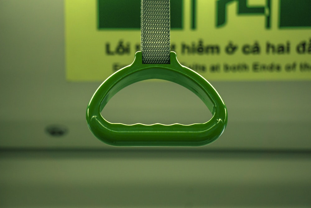 Un primer plano de una manija verde en un autobús