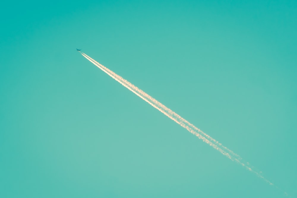 Un avión vuela en el cielo dejando un rastro