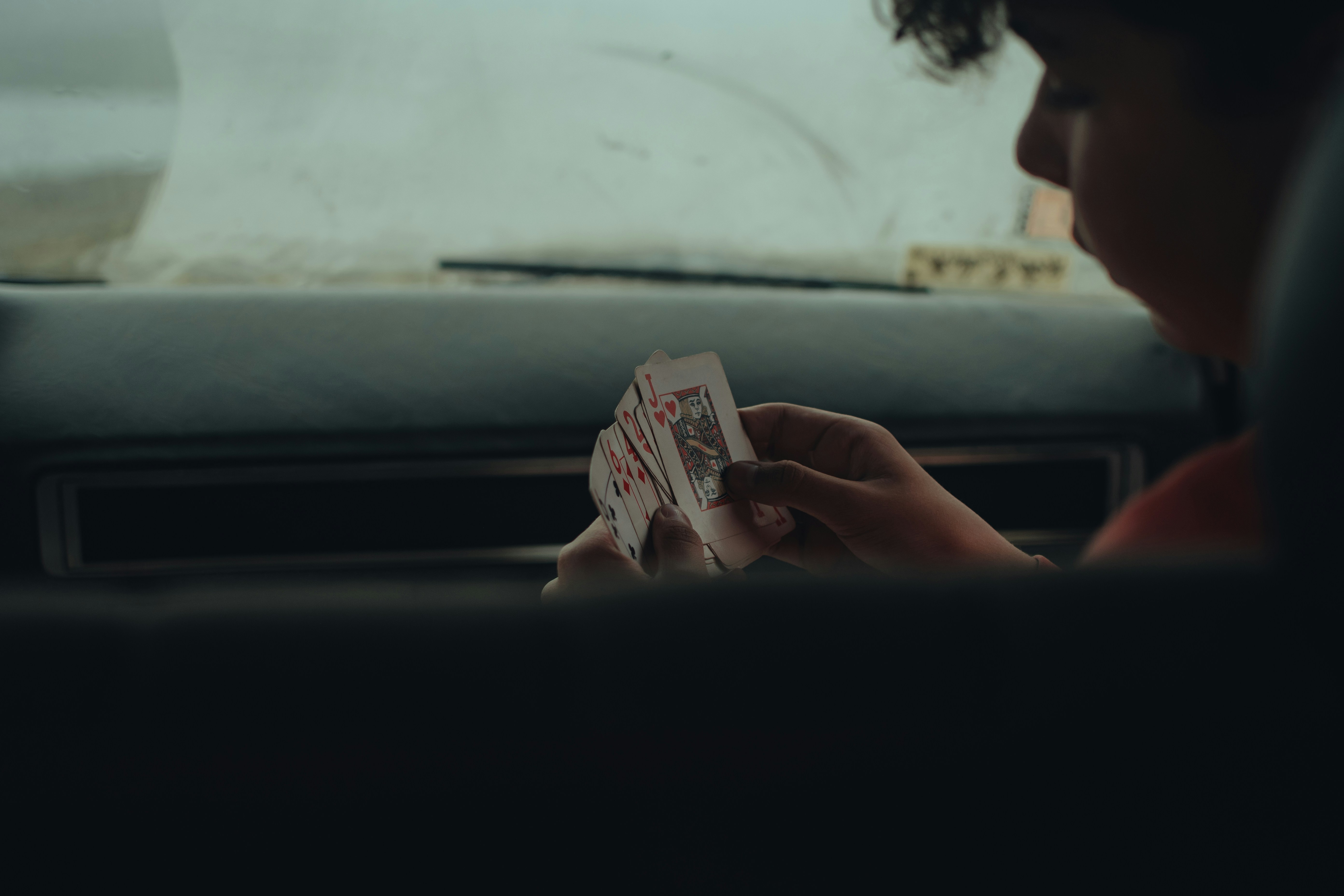 a person sitting in a car holding a piece of paper