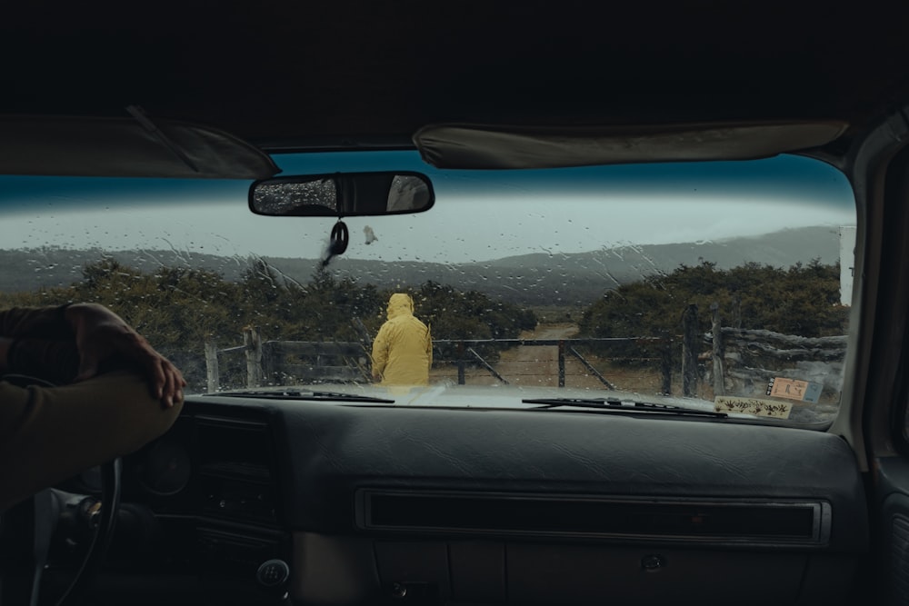 a person in a yellow raincoat sitting in a car