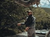 a man standing next to a tree near a body of water
