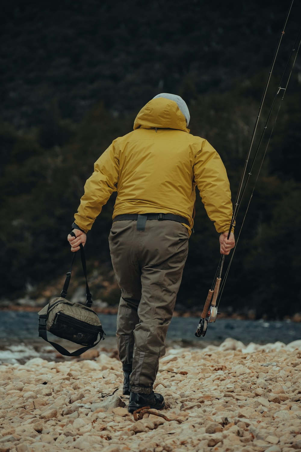 A man in a yellow jacket holding a fishing rod photo – Free Brown Image on  Unsplash